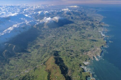 Vista de la costa de Asturias con Llanes y la cordillera Cantábrica al fondo.