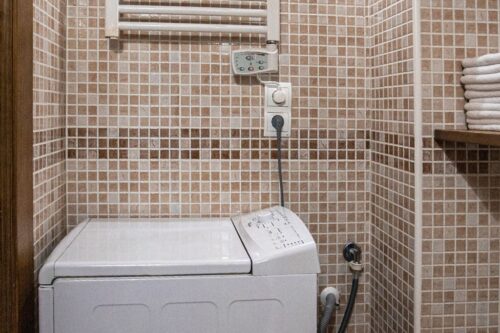 Detalle de lavadora y radiador-toallero en el baño de los apartamentos 1 y 2.