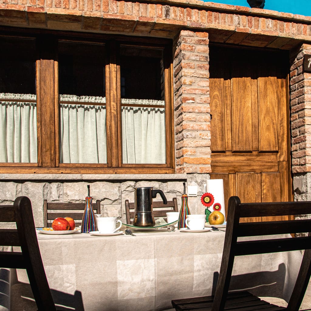 Mesa preparada para desayuno en la terraza de la casa de los Apartamentos Marrubiu.